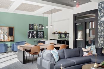 a living room with a blue couch and a table and chairs